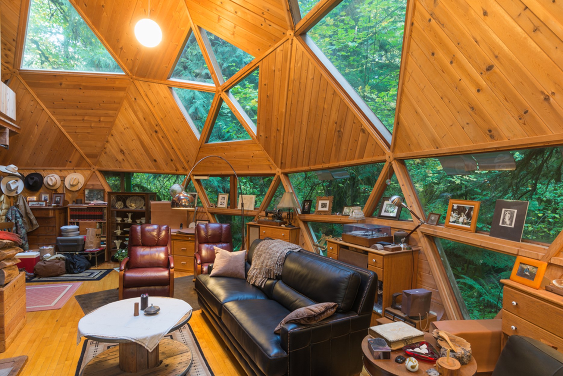 An interior view of an earth dome with wood panels and glass detailing the dome shape.
