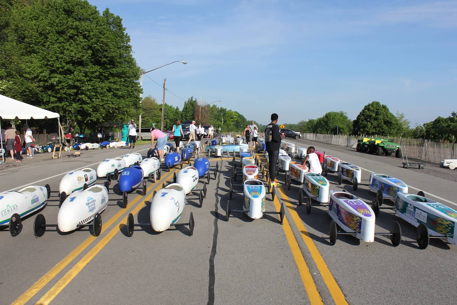 Racers making final adjustments to prepare for a race in the Greater Rochester Soap Box Derby.