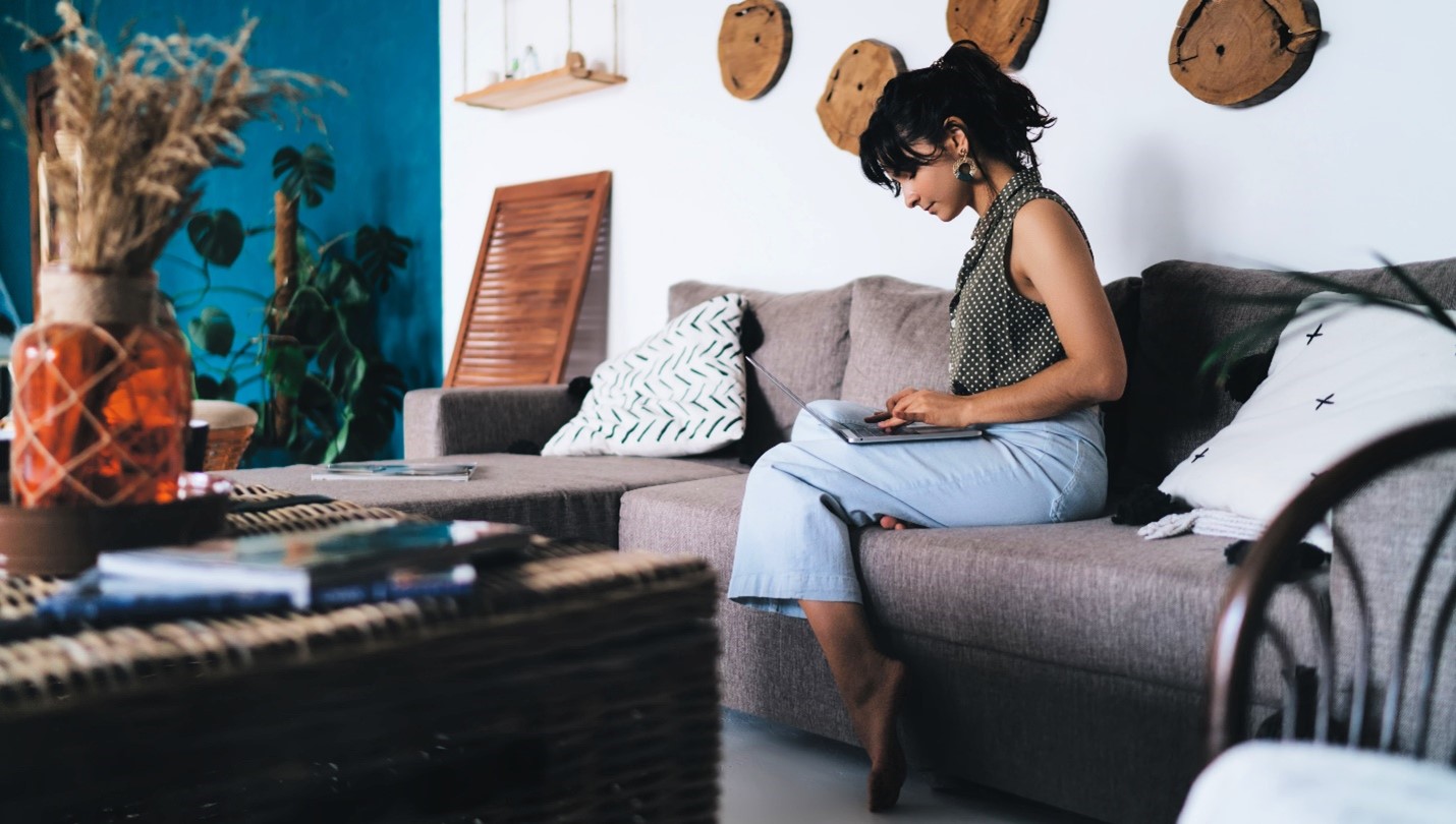 A person sitting in their well-decorated home on their laptop.