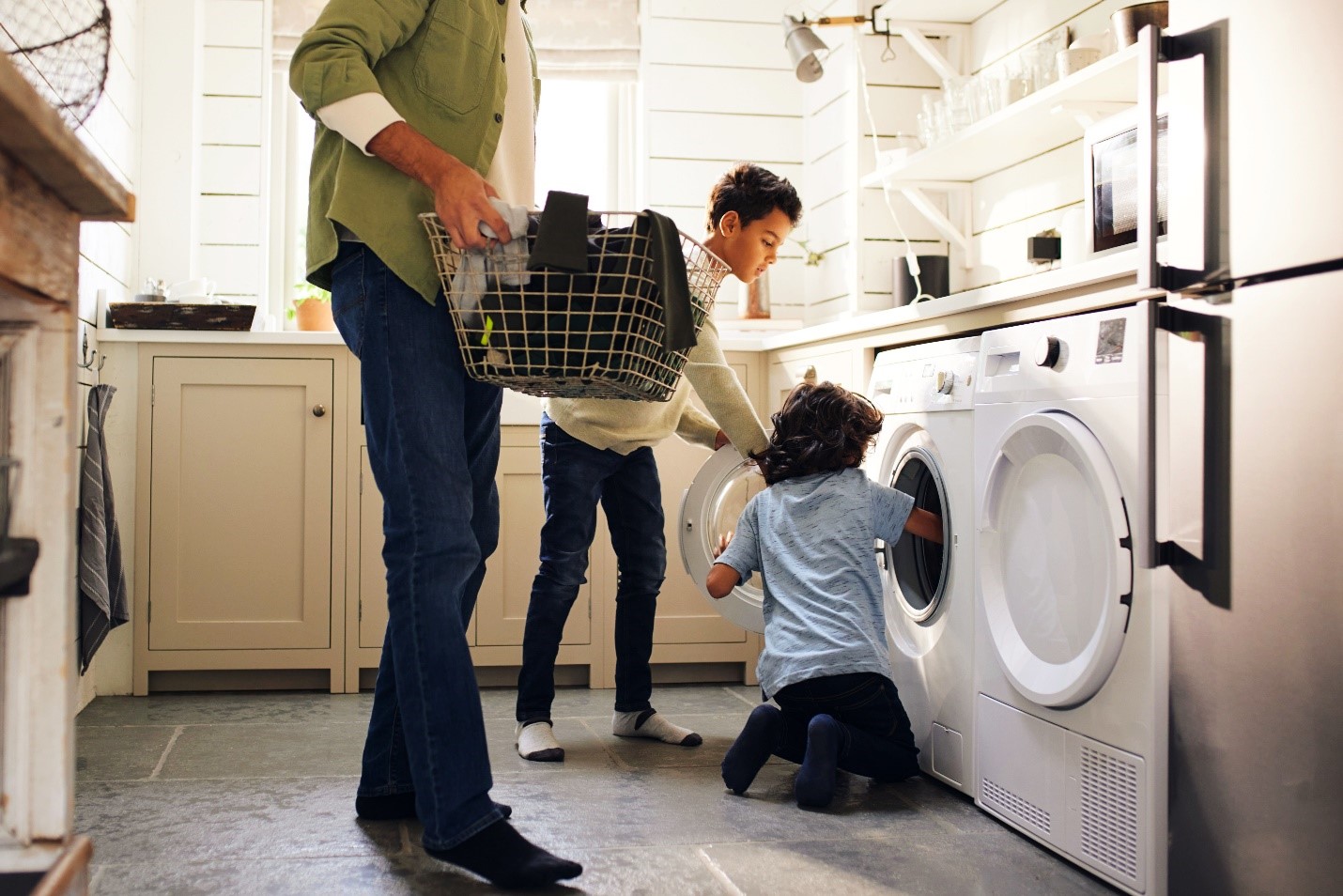 Children helping their father do laundry chores.