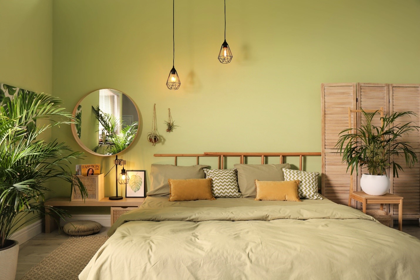 A green monochromatic bedroom with edison bulbs.