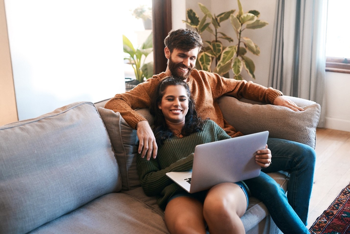A couple looking at a laptop together.