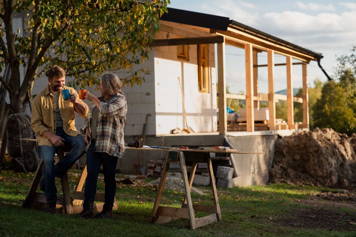 A couple sharing coffee outside as they plan their next home renovation.